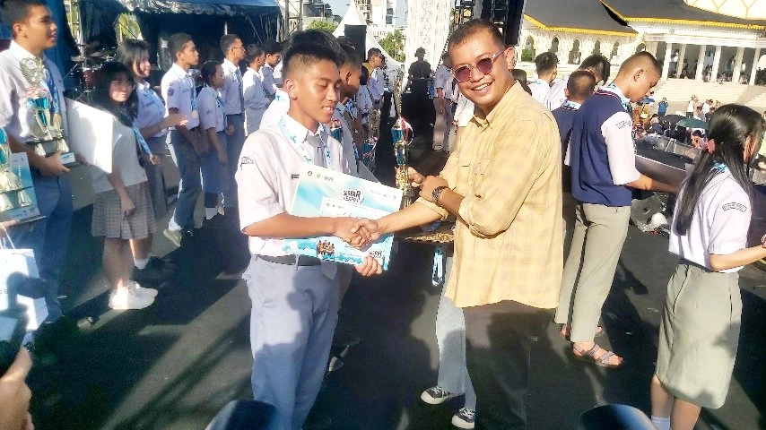 David Eltom Nainggolan menyerahkan piagam dan berjabat tangan dengan siswa pemenang lomba pada penutupan Expo Pendidikan Sumut 2026.